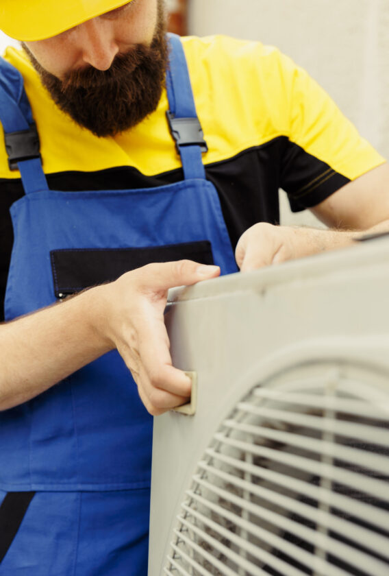 Close up of seasoned repairman installing condenser after replacing faulty unit. Adept worker commissioned to optimize air conditioner system performance, making sure it operates at maximum potential